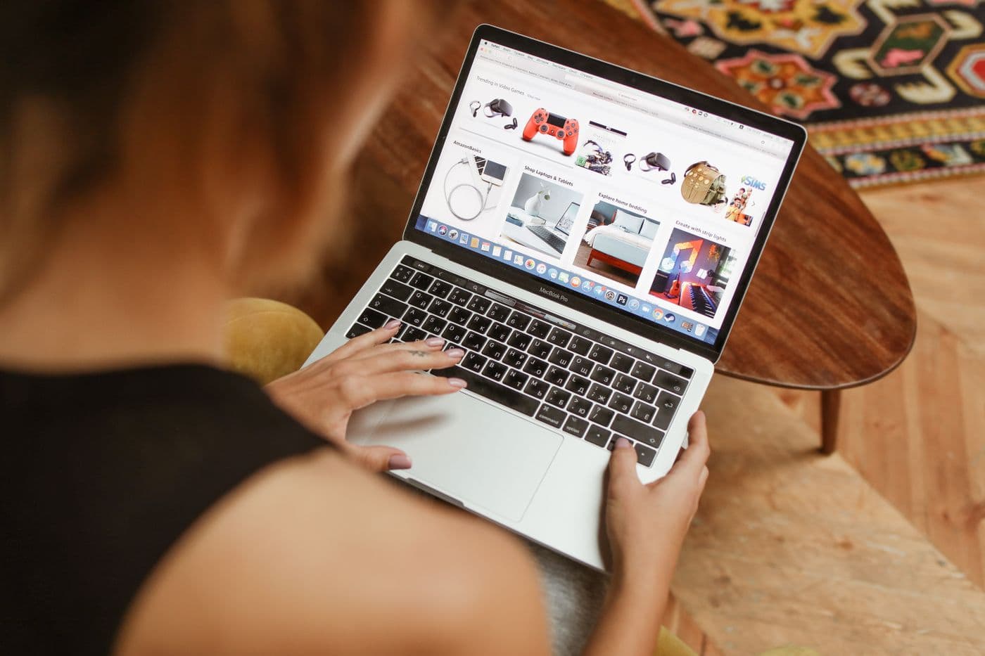 Perempuan menelusuri halaman toko online berisi deretan produk di layar laptop
