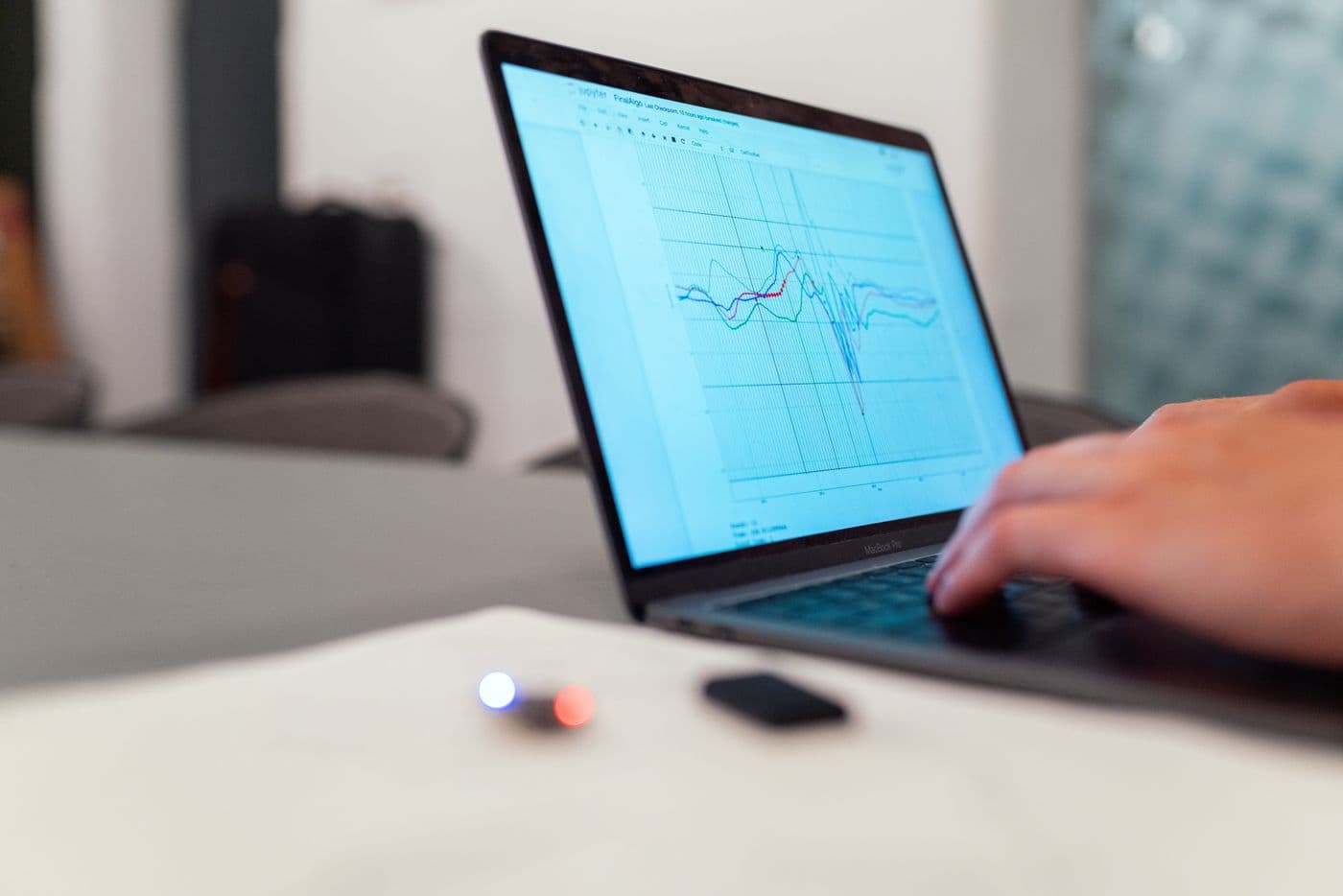 Seseorang mengamati grafik data yang ditampilkan di layar laptop